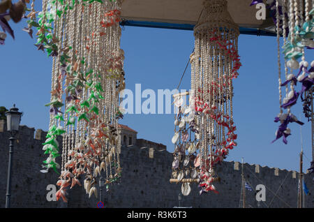 Mediterranean wind chimes made of seashells on the background of the fortress wall and blue sky Stock Photo
