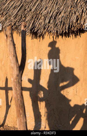 Shadow of a Himba woman on the side of a village hut in a remote village near Opuwo. Stock Photo