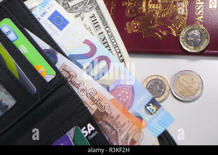 Pounds, euros, dollars, credit and store cards in a British wallet. Stock Photo