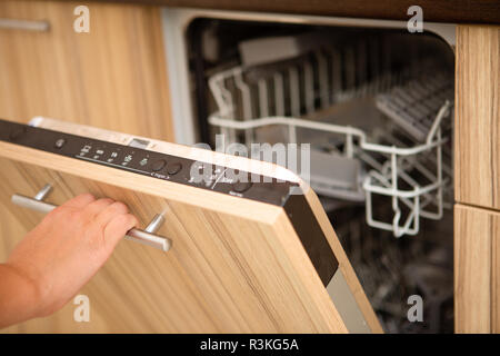 Image of a dishwasher and human hand Stock Photo