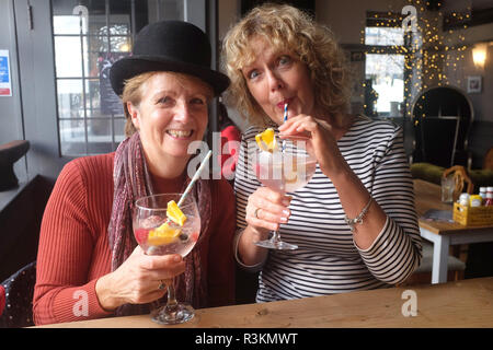 Women one wearing a bowler hat in the Cobb Arms drinking a large gin and tonic with paper straws UK Stock Photo Alamy