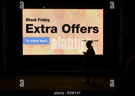 London, UK.  23 November 2018.  People pass advertising signs on display near Piccadilly Circus on Black Friday.   Traditional retailers face increasing challenges to attract customers from their online competition. Credit: Stephen Chung / Alamy Live News Stock Photo