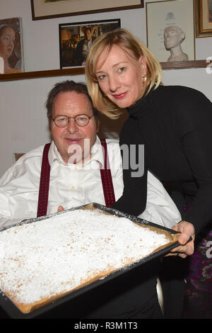 Icking, Germany. 23rd Nov, 2018. The actor and cabaret artist Ottfried Fischer receives his favourite cake from the cult series 'Bulle von Bad Tölz', a tin streusel cake, from his partner Simone Brandlmeier in the Hollerhaus. The Künstlerhaus celebrates its 100th anniversary and was its film home as 'Pension Resi' in the 'Bulle von Bad Tölz'. Credit: Ursula Düren/dpa/Alamy Live News Stock Photo
