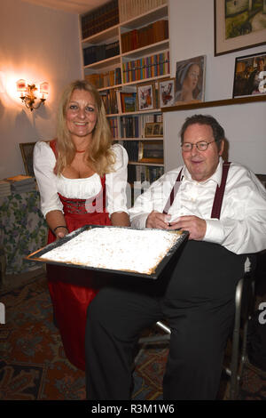 Icking, Germany. 23rd Nov, 2018. The actor and cabaret artist Ottfried Fischer is presented with his favourite cake from the cult series 'Bulle von Bad Tölz', a sheet metal streusel cake, by Lia Stöckl, managing director of the Hollerhaus. The Künstlerhaus celebrates its 100th anniversary and was its film home as 'Pension Resi' in the 'Bulle von Bad Tölz'. Credit: Ursula Düren/dpa/Alamy Live News Stock Photo