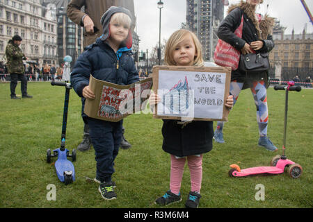 London UK. 24th November 2018. Siblings Frank and Lila hold placards Climate change activists from Extinction Rebellion continue their protest in Parliament Square to urge the government to take action on environmental issues and global warming which is affecting the planet Credit: amer ghazzal/Alamy Live News