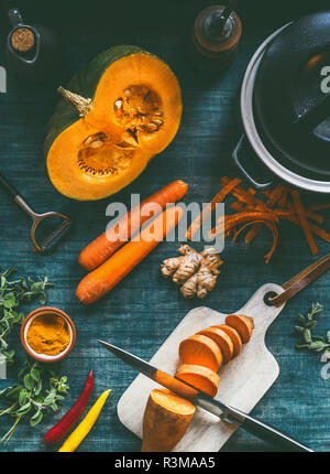 Ingredients for healthy soup or vegetables stew with orange color vegetarian ingredients : pumpkin, carrots, sweet potatoes , turmeric, ginger and chi Stock Photo