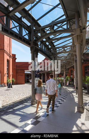 Poland shopping centre center, rear view of young people approaching the entrance to the Stary Browar shopping mall in the city of Poznan, Poland. Stock Photo