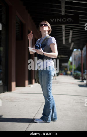 Casual Woman enjoying warmth of sun on the street of New York City Stock Photo