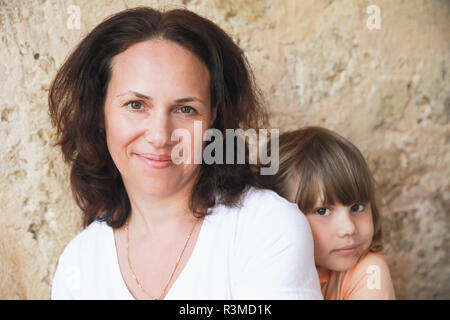 Smiling young adult Caucasian mother with her little daughter, close-up portrait Stock Photo