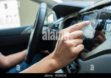 closeup of a young caucasian man using the automotive navigation system of a car Stock Photo