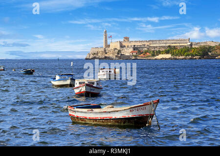 Cuba, Havana. Boats float in front of San Carlos de la Cabana fortress in the Parque Historico Militar Morro Cabana, El Morro Castle Stock Photo