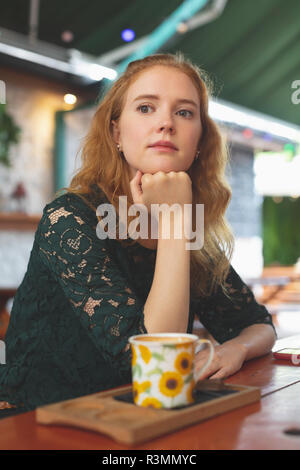 Redhead woman relaxing in cafe Stock Photo