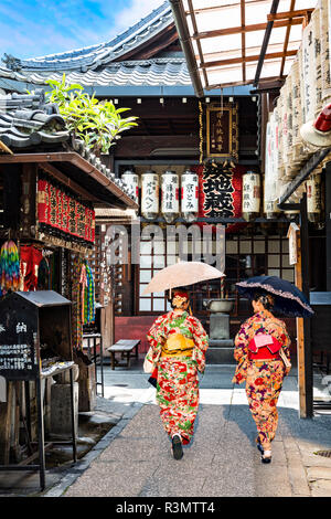 Kyoto, Japan. Two women dressed in kimonos shop Shirakawa-minami-dori, Gion district