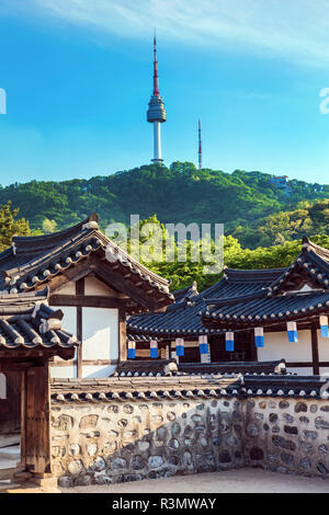 Seoul, South Korea. Traditional Korean village courtyard of Namsangol Hanok with the YTN Seoul Tower (Namsan Tower or Seoul Tower) in the background. Stock Photo