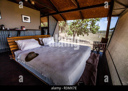 Double bed in Australian outback chic behind the corrugated iron walls of Bamurru Plains Lodge. Wind blows through the fly screens and no one misses air conditioning or Wi-Fi. Northern Territory, Australia Northern Territory, Australia Stock Photo