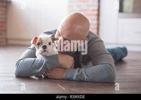 Handsome bold man together with puppy english bulldog Stock Photo