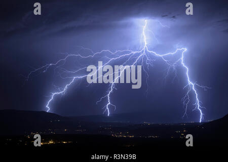 Three branching lightning strikes, near Culoz, in Bugey, Ain, France, July 30, 2017 Stock Photo
