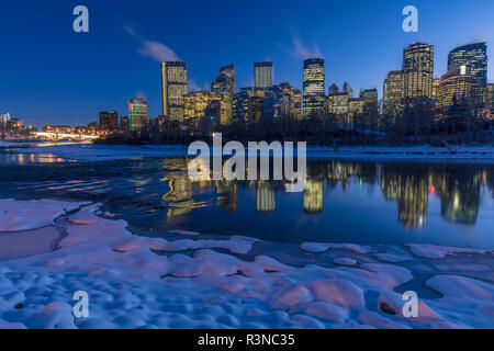 Winter city skyline reflects in the Bow River in Calgary, Alberta, Canada Stock Photo