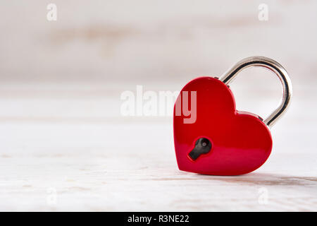 Red padlock hearts on white wooden background. Copyspace Stock Photo