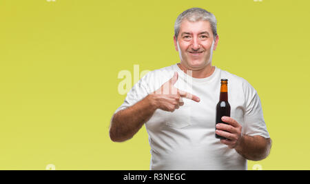 Handsome senior man drinking beer bottle over isolated background very happy pointing with hand and finger Stock Photo