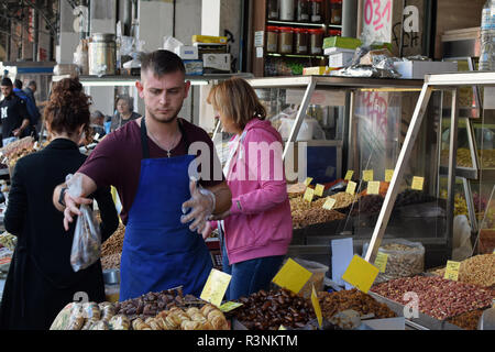 ATHENS, GREECE - OCTOBER 17, 2018: Vendors and customers at dried fruit and nuts market on Athinas street. Stock Photo