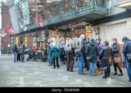 People waiting patiently in line in front of  movie theatre in Groningen, The Netherlands, to buy tickets for International Film Festival Stock Photo