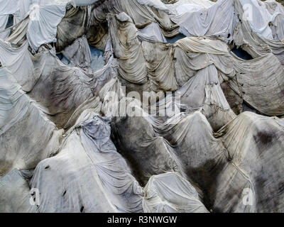 Climate | Albedo | Rhone: Huge fleece blankets cover parts of the Rhone Glacier in Switzerland in an attempt to stall the inevitable melting of the snow and ice. After a winter with record amounts of snow, most of it was gone when this image was taken on July 14th 2018, exposing the darker ice. While snow is a brilliant reflector of the energy from the sun, the darker ice absorbs the energy instead, accelerating the melting of the glacier. The color and darkness of glacier ice vary all over the world, depending on build-up of pollution, age of the ice, particles picked up by the ice and by mic Stock Photo