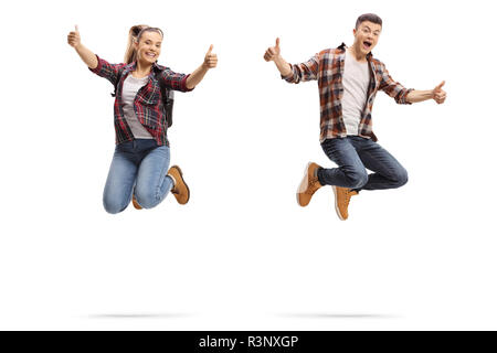 Teen boy and girl jumping and showing thumbs up isolated on white background Stock Photo