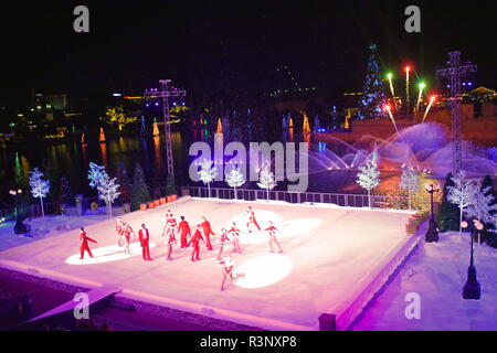 Orlando, Florida. November 21, 2018. Artist group skating at Christmas Show on ice on colorful background with fireworks in International Drive area. Stock Photo