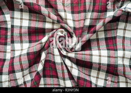 Wrinkled plaid fabric. Background crumpled cloth in a cage. Twisted in the center cloth swatch Stock Photo