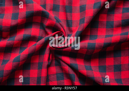 Wrinkled plaid material. Red dark blue checkered shirt cloth background. Twisted in the center cloth swatch Stock Photo