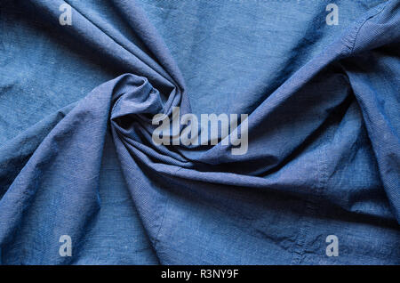 Twisted in the center cloth swatch. Wrinkled texture of blue fabric for shirts. Blank textile background Stock Photo