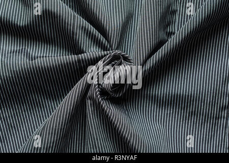 Texture of black cloth with narrow white vertical lines. Twisted in the center cloth swatch Stock Photo