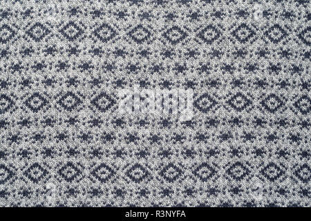 Texture of gray winter sweaters with repeating geometric patterns and small snowflakes. Stock Photo