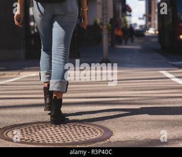 Woman walking in city on a sunny day Stock Photo