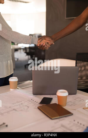 Executive shaking hands in office Stock Photo