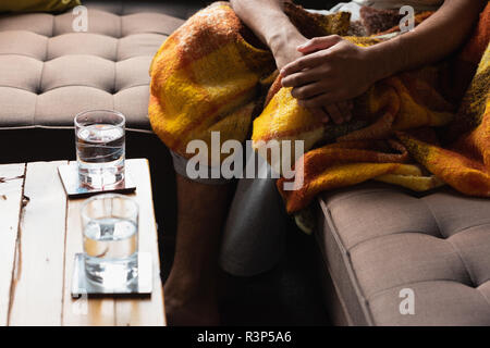 Man sitting on sofa in living room Stock Photo