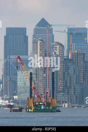 Jack up barge Commander on the River Thames with Canary Wharf behind. Stock Photo