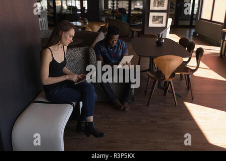 Business colleagues using digital tablet in cafeteria Stock Photo