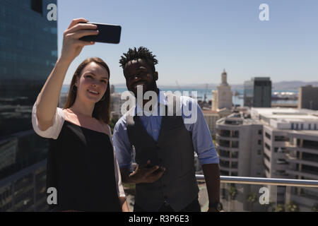Business colleagues taking selfie with mobile at terrace Stock Photo