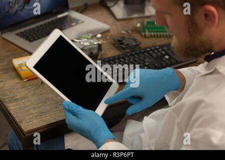 Robotics engineer using digital tablet at desk Stock Photo
