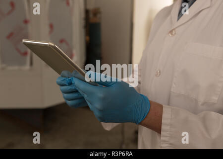 Robotics engineer using digital tablet in warehouse Stock Photo