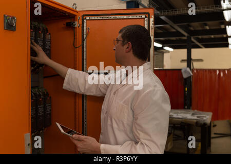 Robotics engineer examining control panel Stock Photo