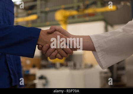 Robotic engineers shaking hands with each other Stock Photo