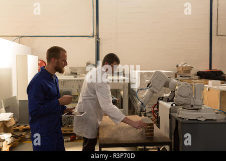 Robotic engineers testing robotic machine Stock Photo