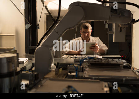 Robotic engineer using digital tablet Stock Photo