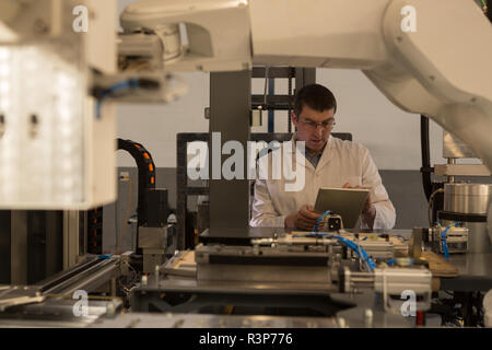Robotic engineer using digital tablet Stock Photo