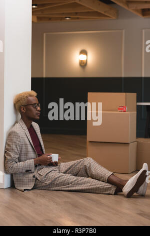 Businessman having coffee in office Stock Photo