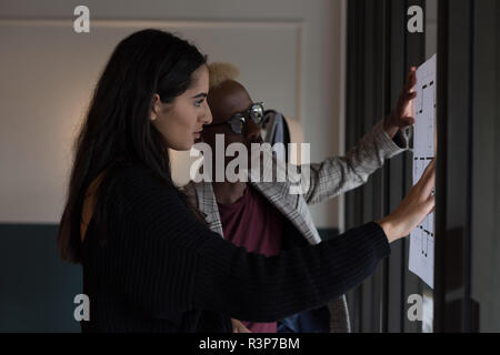 Business executives disusing over a blueprint Stock Photo