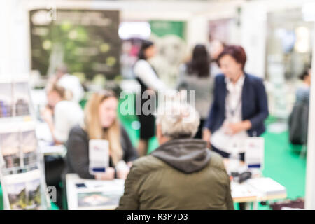 Anonymous blurred people discussing business at a trade fair. Stock Photo